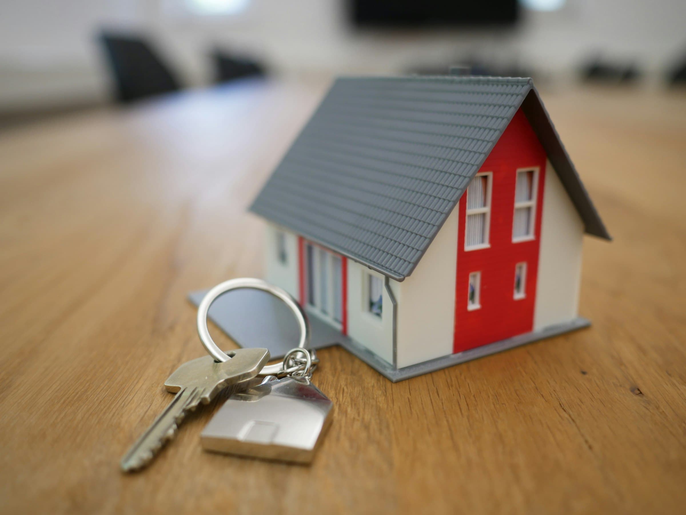 A model house on a table beside a set of keys
